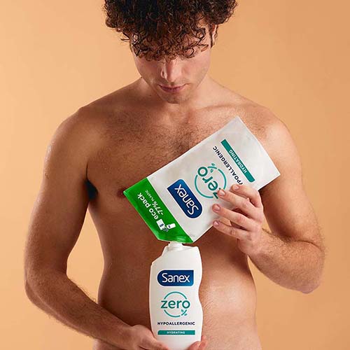 Un homme torse nu verse le contenu d'une recharge éco-pack Sanex Zero% dans un flacon réutilisable.
