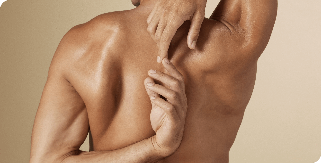 Vue de dos d'un homme au dos musclé en train de s'étirer, ses mains tentant de se rejoindre derrière son dos.