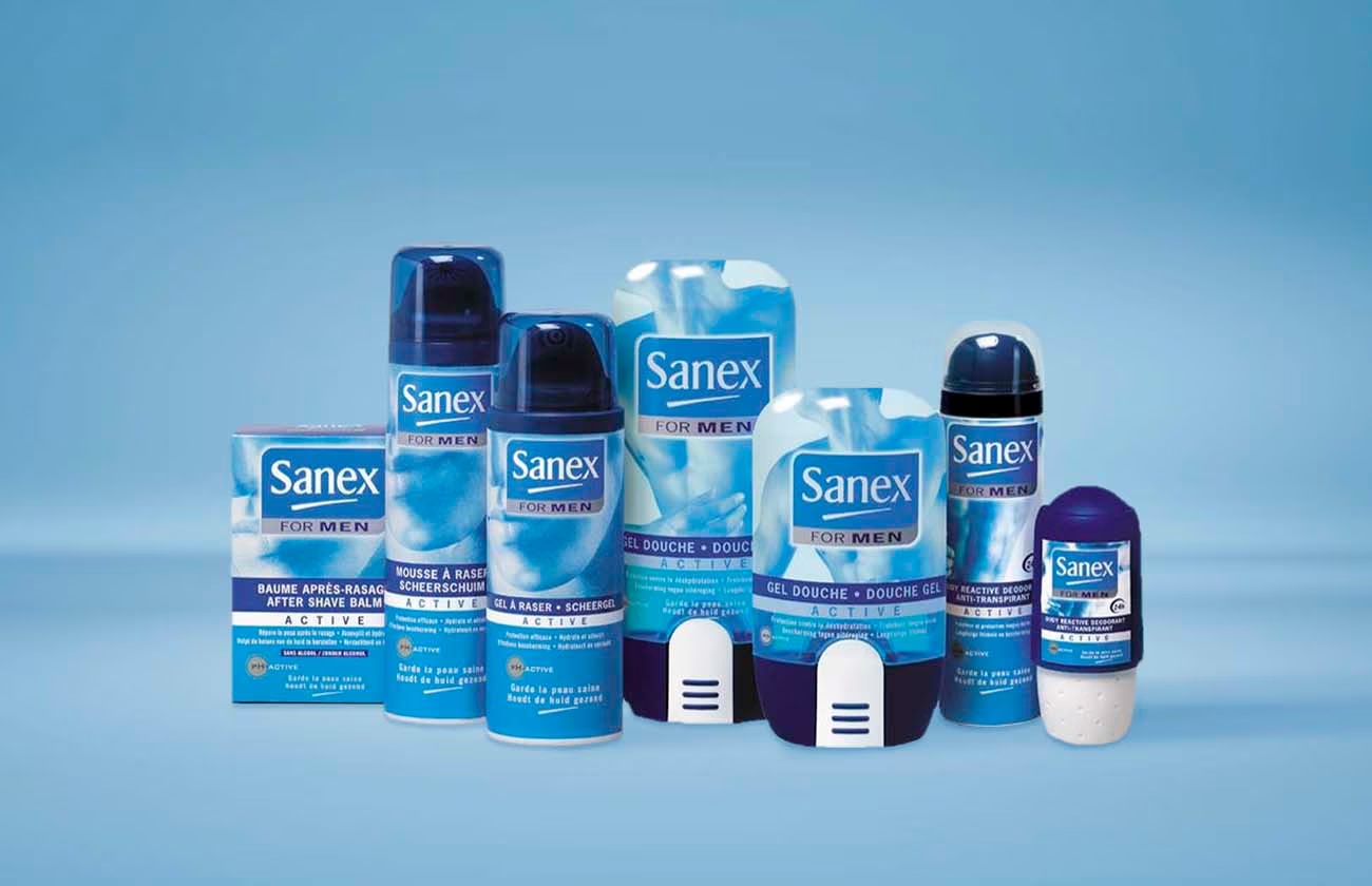 Gamme de produits Sanex For Men Active, incluant baume après-rasage, mousse à raser, gel douche et déodorant, tous présentés dans leur emballage bleu et blanc.